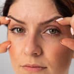 Close-up portrait of Caucasian middle-aged woman showing expression lines around eyes. Signs of aging on the face.