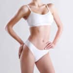 Torso of slim attractive female with flat belly in white underwear