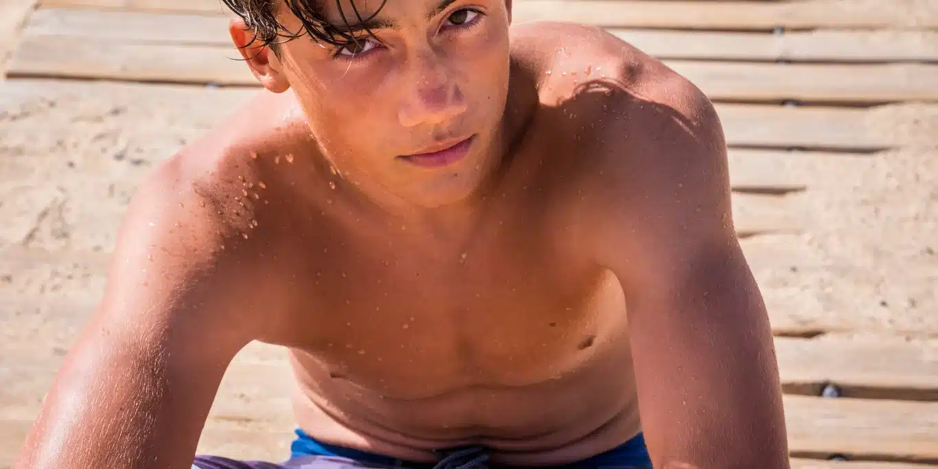 Boy Sitted On The Sand And On The Wood At The Beach Boy Sitted On The Sand And On The Wood At The Beach